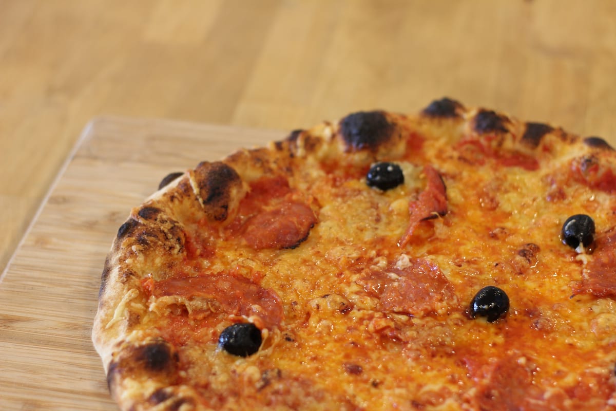 Pizza Chorizo garnie de Sauce tomate, Chorizo, Emmental français et Olives noires