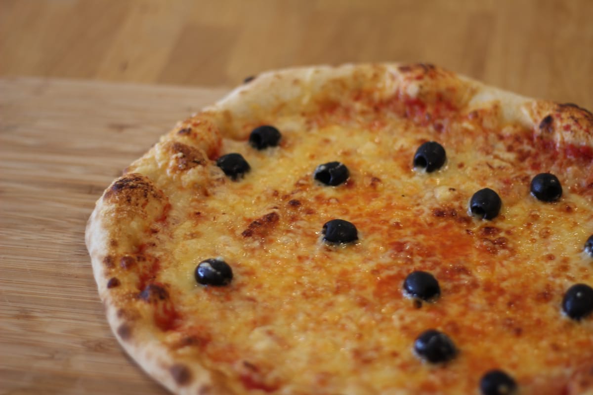 Pizza Marguerite garnie de Sauce tomate, Emmental français et Olives noires